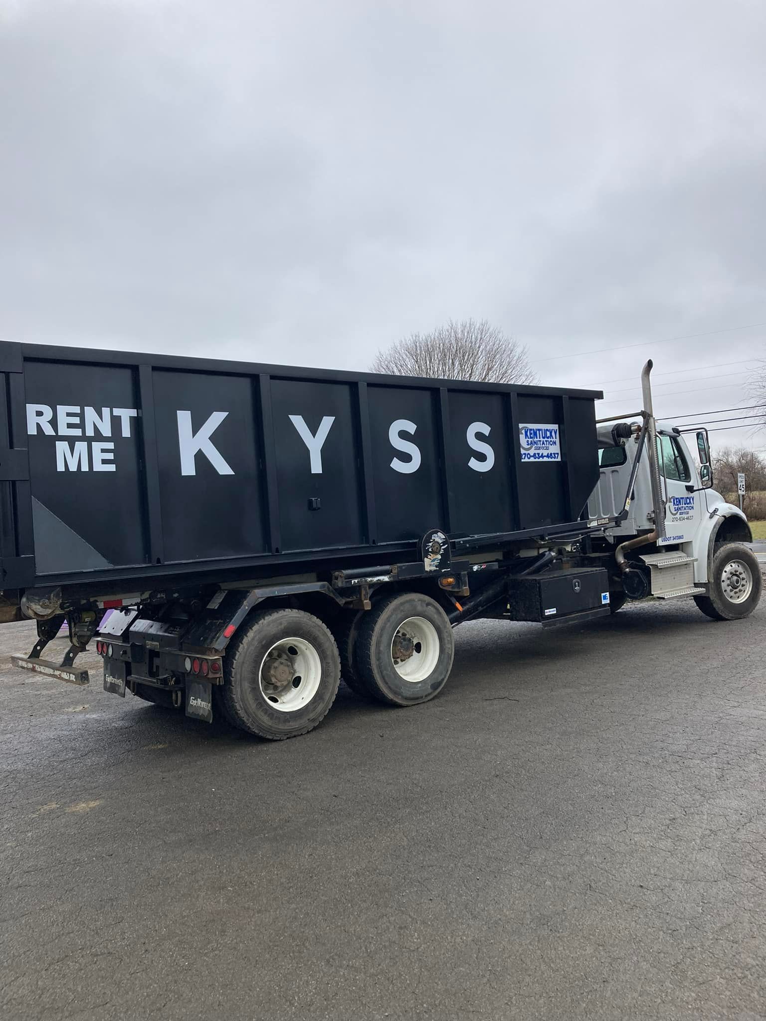 Kentucky Sanitation Services roll-off truck with KYSS dumpster